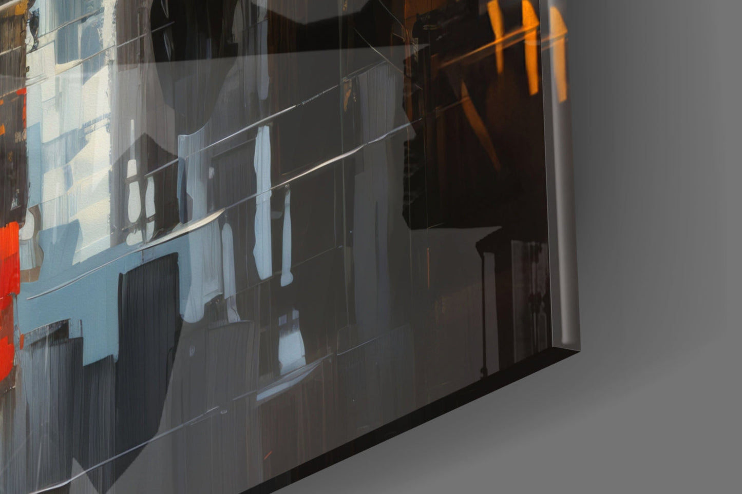 Close-up angled view of glass wall art showing reflective surface with blue-toned building facade, windows, and orange accent colors.