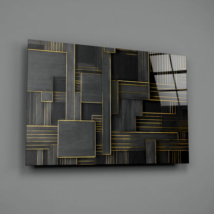 Modern geometric glass wall art with layered rectangular shapes in charcoal, black, and gold accents on gray background.