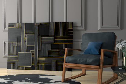 Black and gold geometric glass wall art panel displayed above a mid-century modern wooden armchair in a contemporary living room setting.