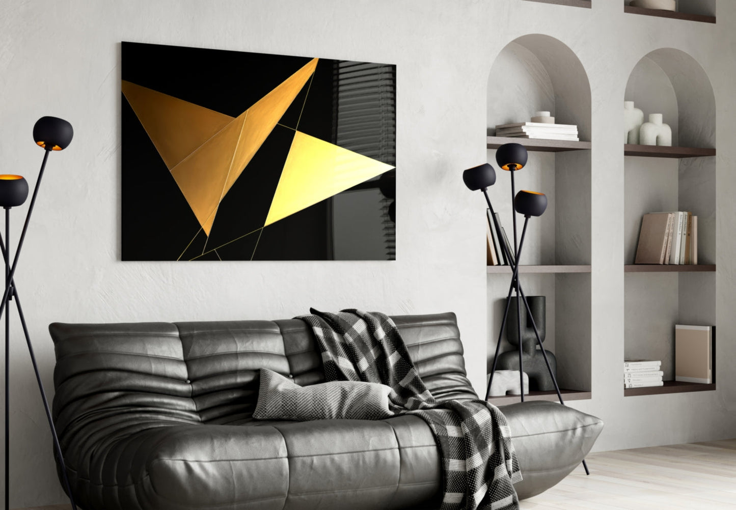 Black and yellow geometric glass wall art with triangular shapes displayed above a gray leather sofa in a modern living room interior.