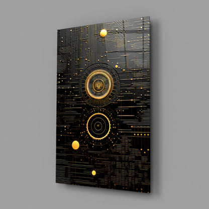 Angled view of black glass wall art with gold concentric circles, circuit-line patterns, and illuminated golden spheres against gray background.