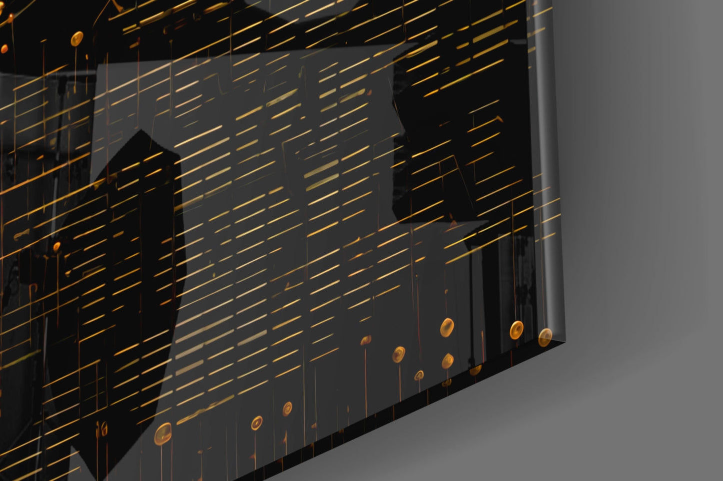 Angled view of glass wall art with gold horizontal lines, black silhouettes, and dangling gold circular elements against gray background.