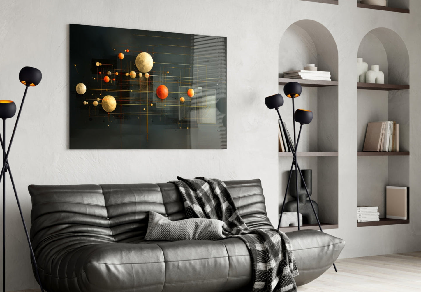 Modern living room with black leather sofa displaying planets glass wall art featuring gold and orange spheres on dark background.