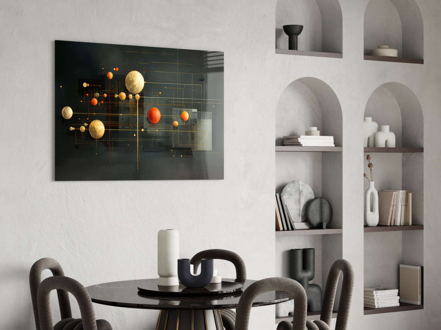 Modern dining room featuring black glass wall art with gold and orange spheres on geometric grid, displayed above round black table with gray upholstered chairs and white built-in shelving.