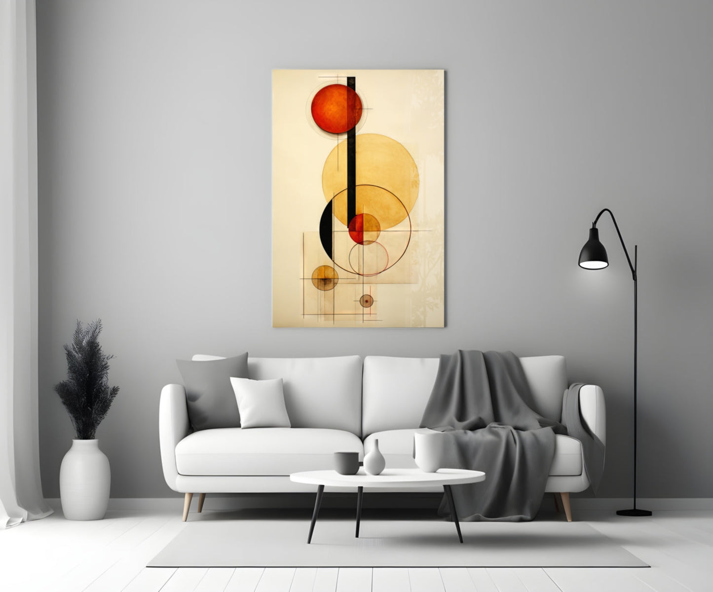Abstract geometric glass wall art with red, yellow, and black circles and lines displayed above a white sofa in a modern living room.