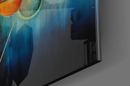 Angled view of colorful glass wall art with orange and blue gradient design, mounted on white wall with shadow cast across surface.