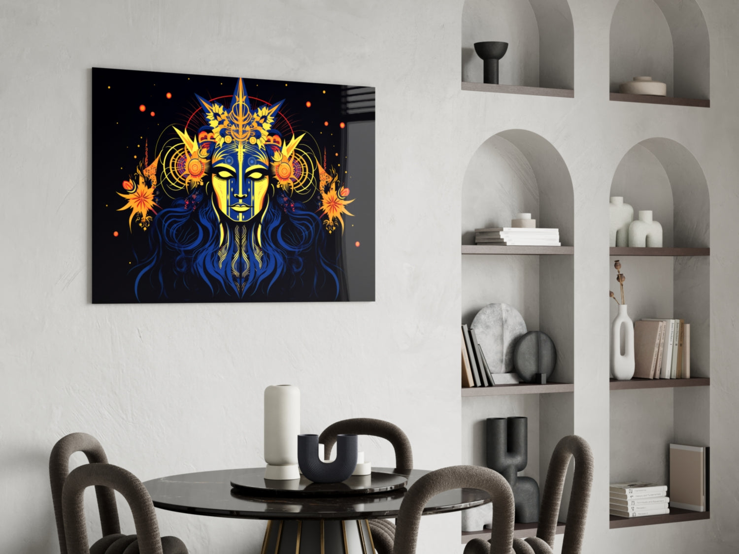 Colorful glass wall art depicting a celestial face with blue hair and golden ornaments hangs above a modern dining table with curved chairs and built-in wall shelving.