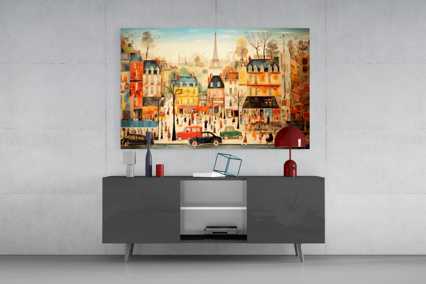 Colorful illustrated Paris street scene glass wall art hung above a dark gray modern console table with decorative accessories.