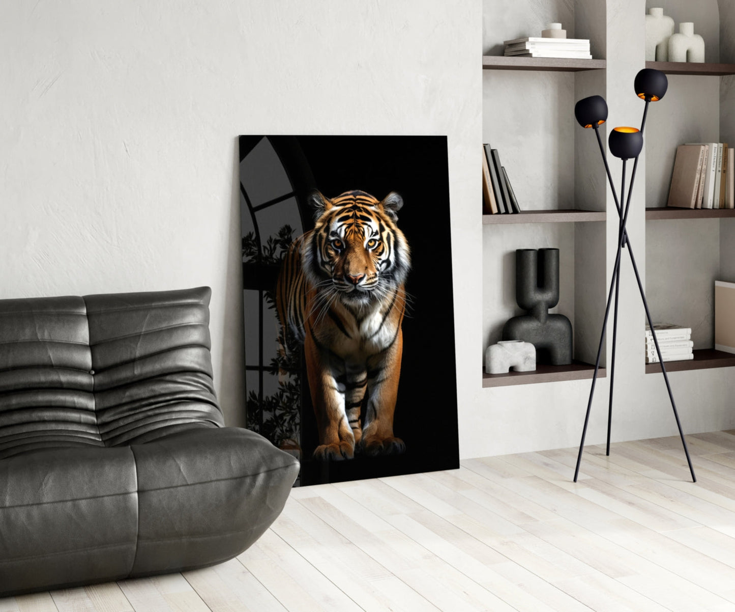 Glass wall art depicting a tiger against a black background displayed in a modern living room with gray furniture and white shelving.