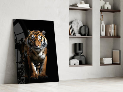 Tiger glass wall art leaning against white wall beside shelving unit displaying books and decorative objects.