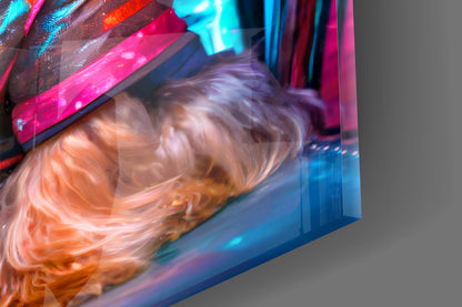 Close-up of vibrant orange and cream swirled glass with neon pink and cyan lighting reflecting across the surface.