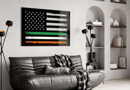 Black glass wall art featuring USA and Ireland flags with white, green, and orange horizontal stripes displayed above gray leather sofa in modern living room.