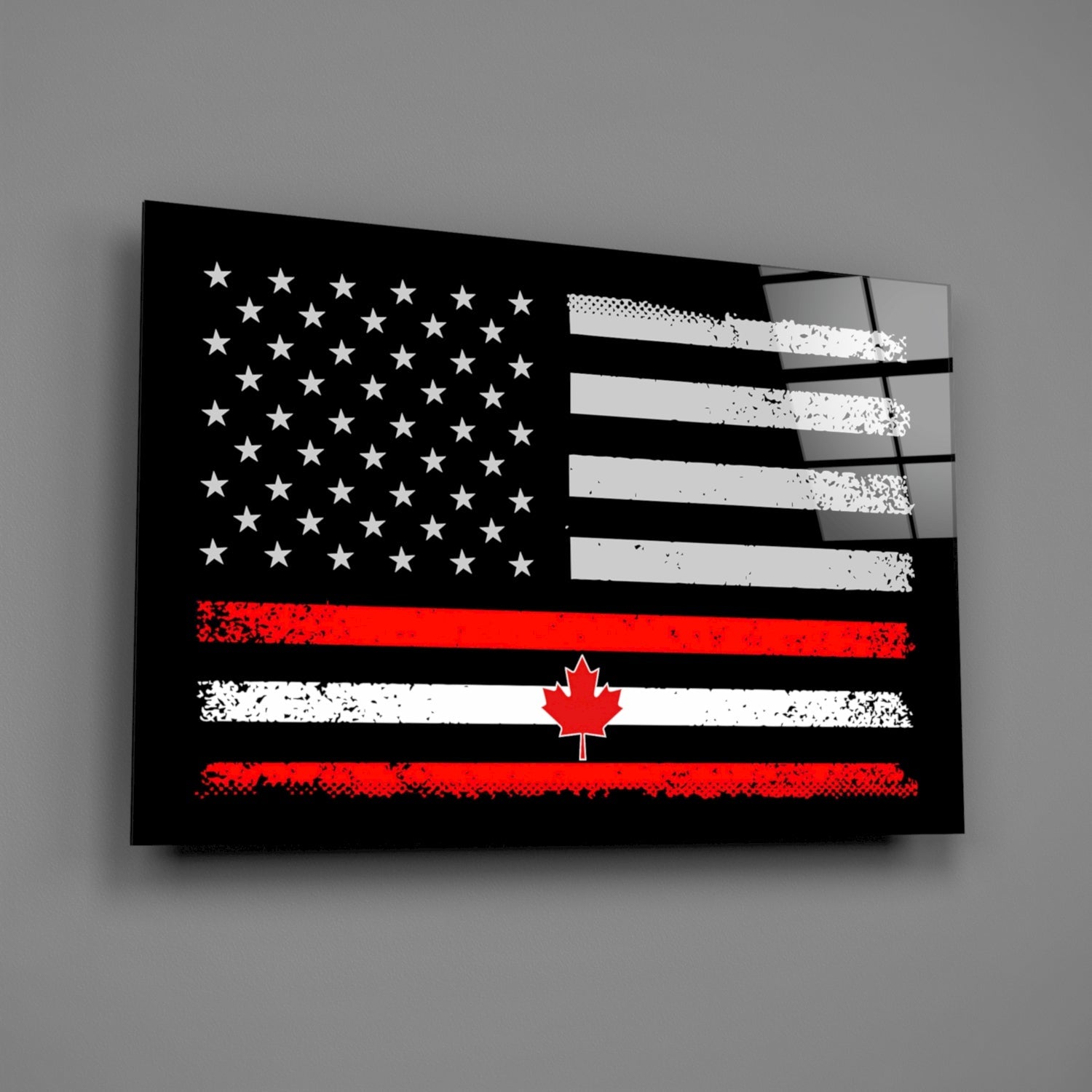 Black glass wall art featuring merged USA and Canadian flags with white stars, red and white stripes, and maple leaf, displayed at angle against gray background.