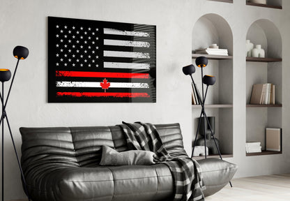 Black glass wall art featuring distressed USA and Canadian flags with red maple leaf stripe, displayed above gray leather sofa in modern living room.