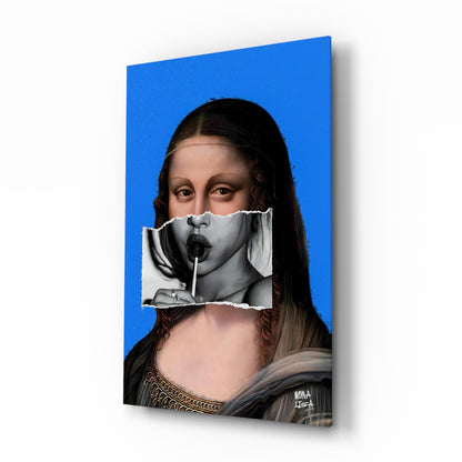 Angled perspective of glass wall art featuring Mona Lisa portrait with torn paper effect revealing black and white face, vibrant blue background, and artist signature.
