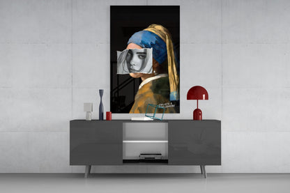 Modern living room display showing contemporary glass wall art of girl with pearl earring and blue headwrap above gray media console with red lamp.
