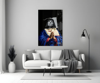 Contemporary Virgin Glass Wall Art depicting a figure in blue and red robes holding a cream-colored cloth against a black background, displayed above a white sofa.