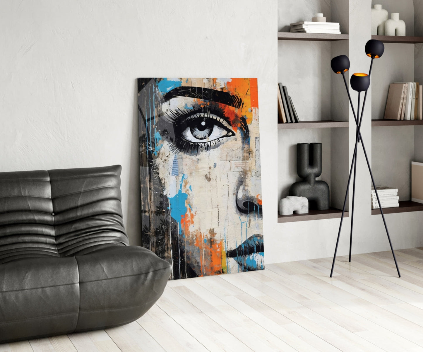 Modern living room interior featuring a half-portrait glass wall art with blue, orange, and black artistic eye design displayed against white wall.