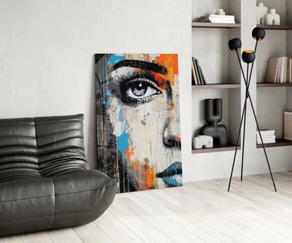 Modern living room interior featuring a half-portrait glass wall art with blue, orange, and black artistic eye design displayed against white wall.