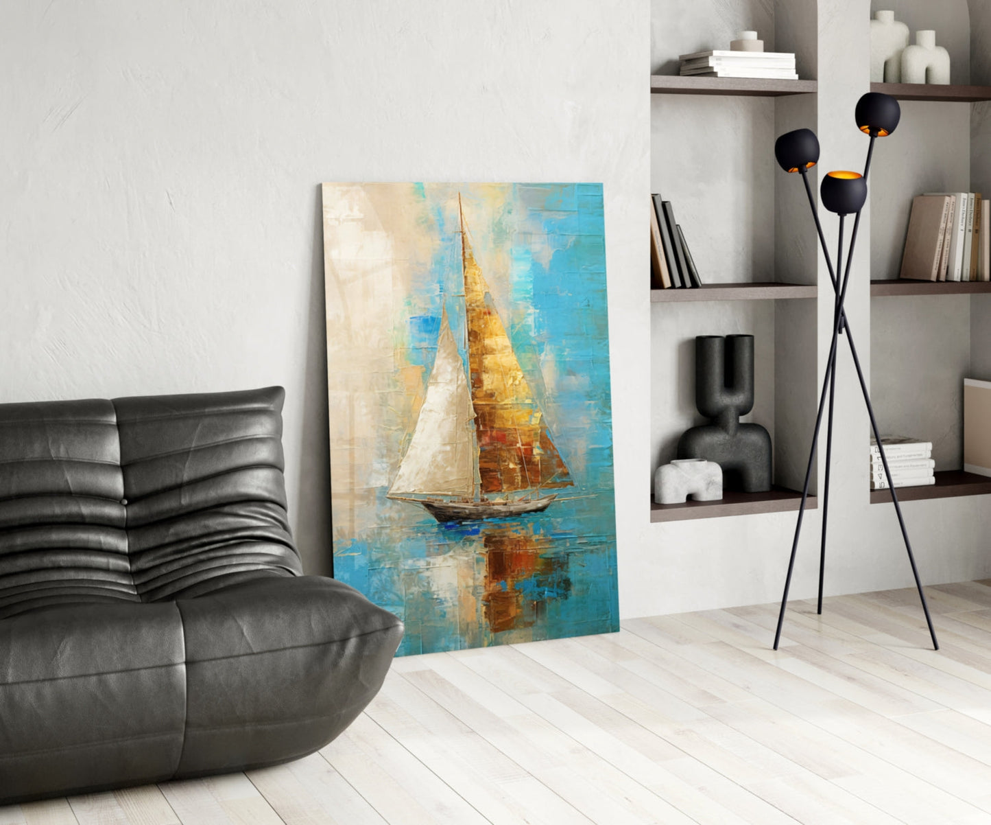Modern living room featuring sailboat glass wall art with blue, gold, and cream tones displayed between black leather chair and white shelving unit.