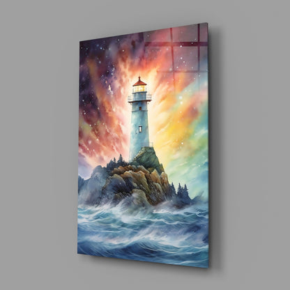 Angled view of glass wall art depicting a lighthouse on rocky cliffs with turbulent waves and vibrant sunset sky in orange, yellow, and blue tones.