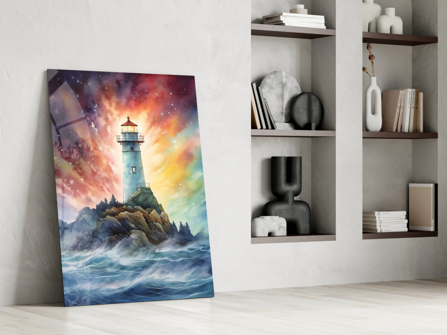 Glass art panel leaning against white wall displays colorful lighthouse on rocky coast with dramatic sunset sky, positioned beside white shelving unit with decorative objects and books.