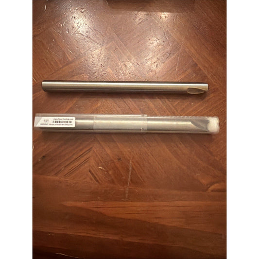 Two metallic chamfer mill drill bits displayed vertically on a wood surface, with the lower one in clear packaging bearing a product label.