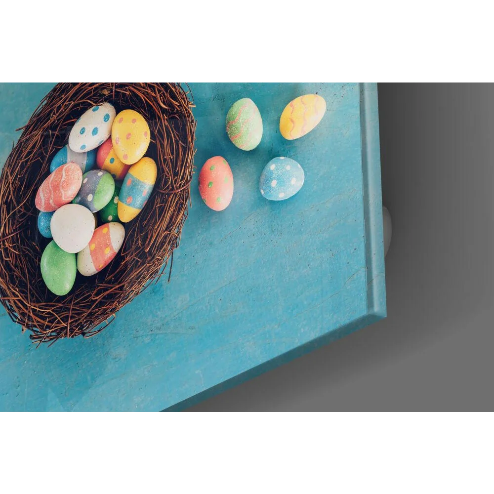 Vibrant hand-painted Easter eggs in pastel shades fill a woven brown nest on glass wall art