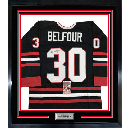 Framed black Chicago Blackhawks hockey jersey #30 with "BELFOUR" nameplate, signed, displayed front-facing with red and white stripes and JSA authentication certificate visible.