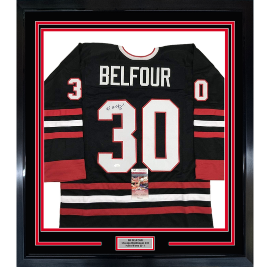 Framed black Chicago Blackhawks hockey jersey #30 with "BELFOUR" nameplate, signed, displayed front-facing with red and white stripes and JSA authentication certificate visible.