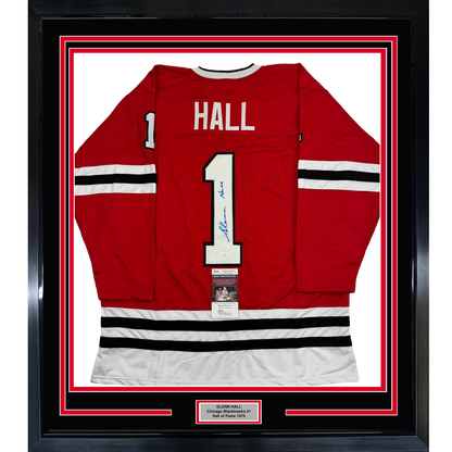 Framed red Chicago Blackhawks #1 hockey jersey with "HALL" nameplate and signature, displayed front-center against white backing with red and black border frame.