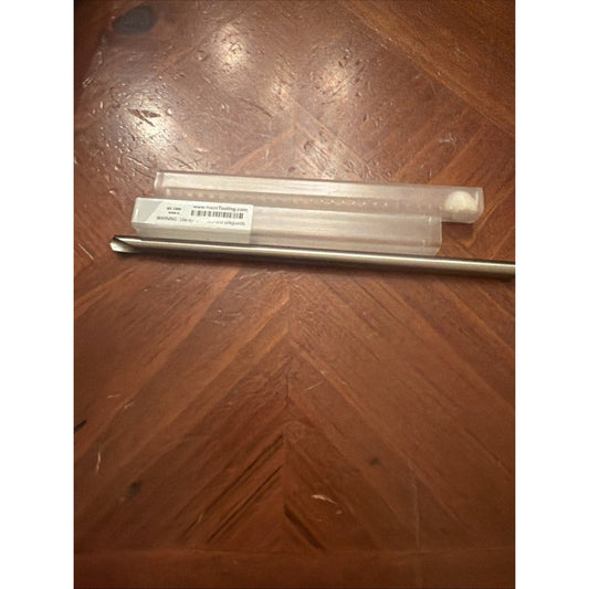Haas carbide chamfer mill in clear plastic packaging with label lying on brown wood flooring, top-down view.