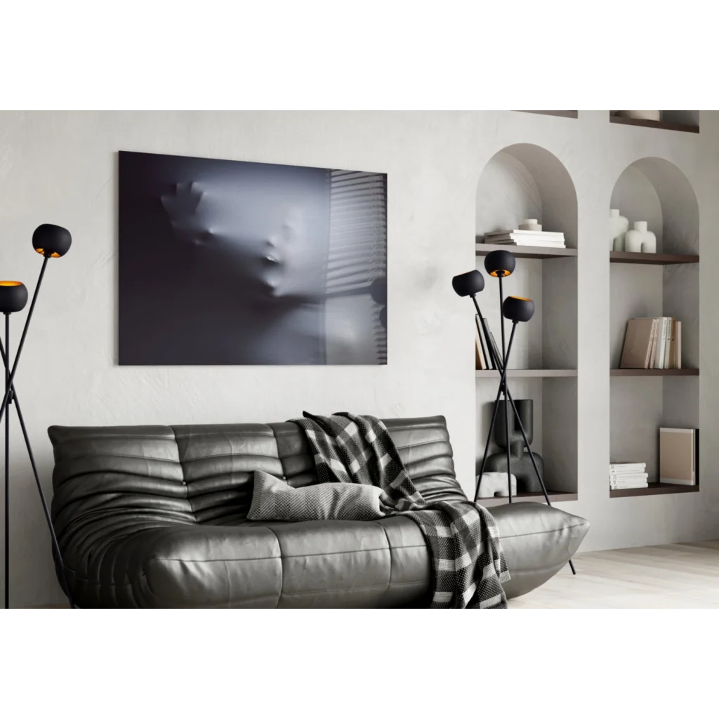 Black leather sofa with tufted cushions and plaid throw under ethereal ghost face wall art