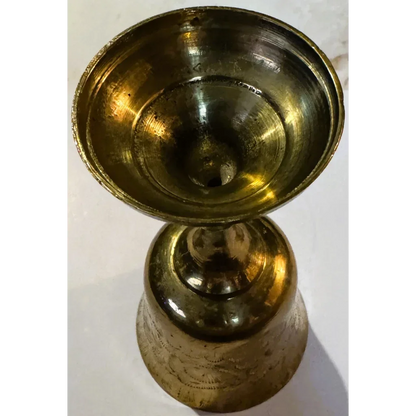 Ornate middle eastern brass oil lamp with floral engravings on the brass chalice