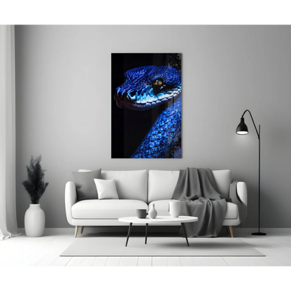 Vibrant blue snake glass wall art with golden eye above white sofa