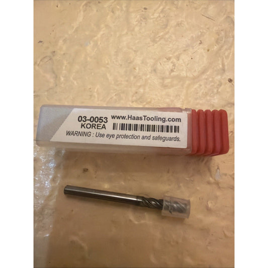 Haas Tooling carbide end mill 03-0053 with red plastic case and product label displayed on tan textured surface.