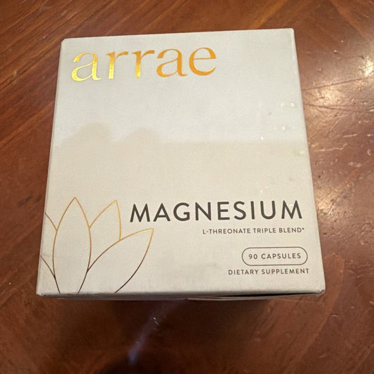White supplement box labeled "arrae MAGNESIUM L-THREONATE TRIPLE BLEND 90 CAPSULES" with gold text, displayed on wooden surface.