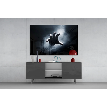 Black-and-white reaching hand through mist wall art on gray console