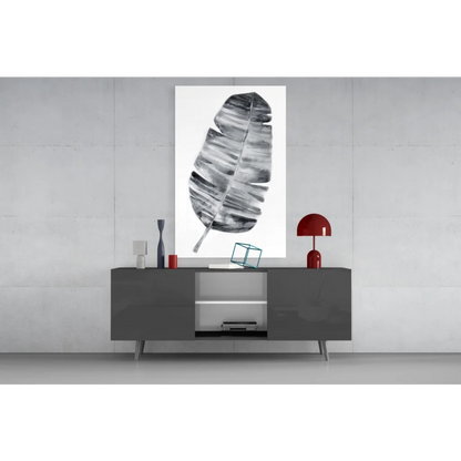 Modern black-and-white banana leaf wall art above gray console