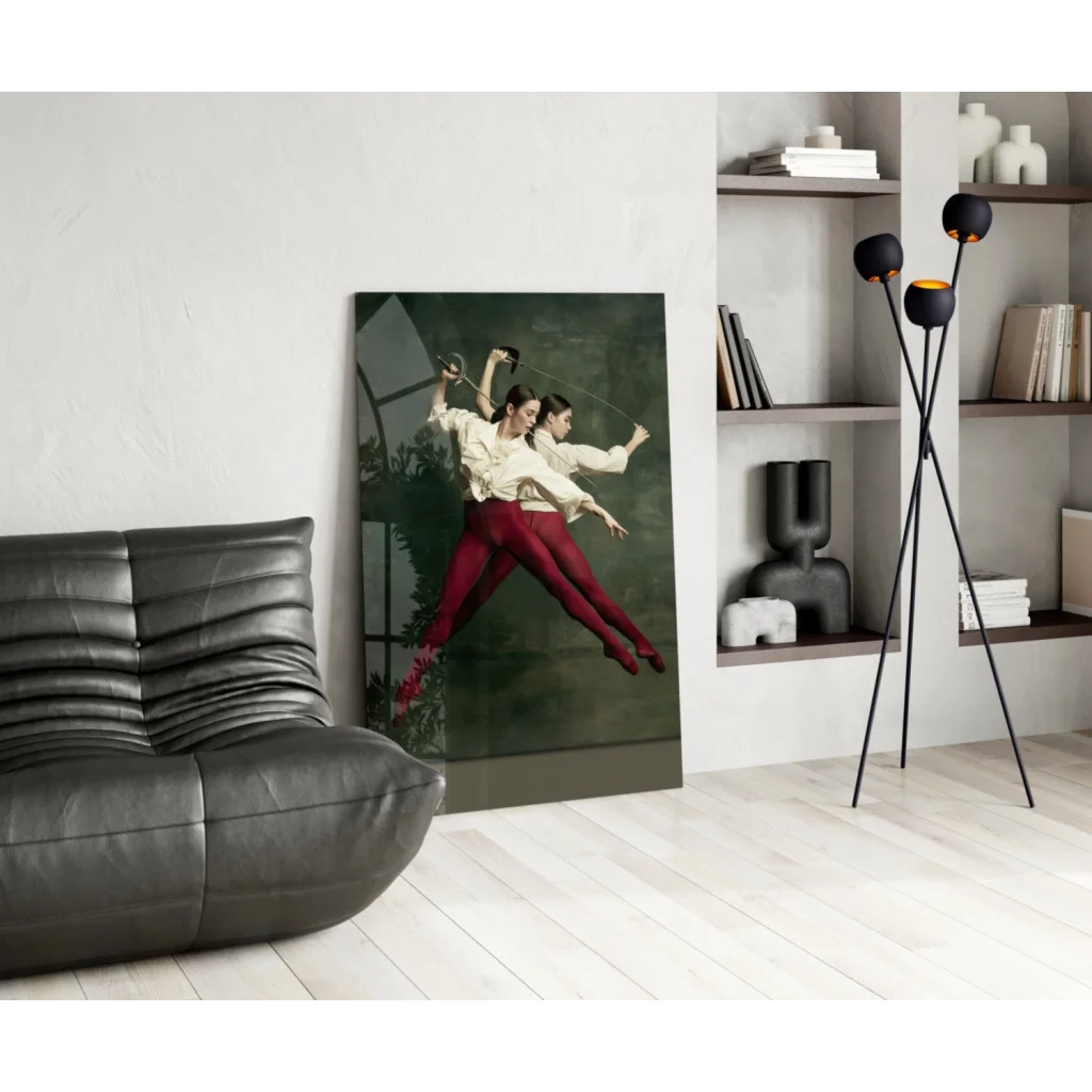 Vibrant glass wall art of two women fencing in cream tops and red pants