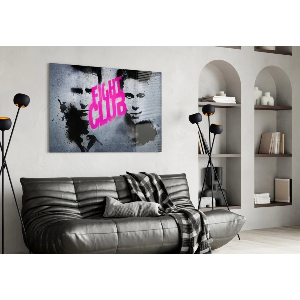 Gray leather sofa with plaid blanket under Fight Club pink graffiti wall art