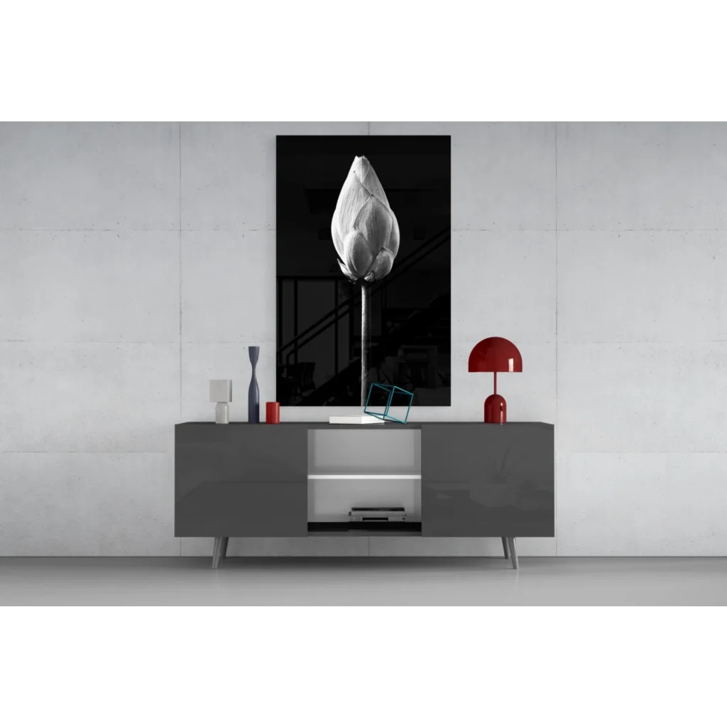 Black and white lotus bud wall art framed above gray console