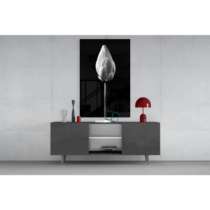 Black and white lotus bud wall art framed above gray console