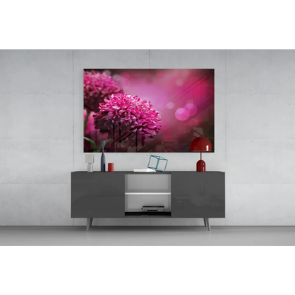 Vibrant pink chrysanthemum glass wall art with bokeh glow above gray console