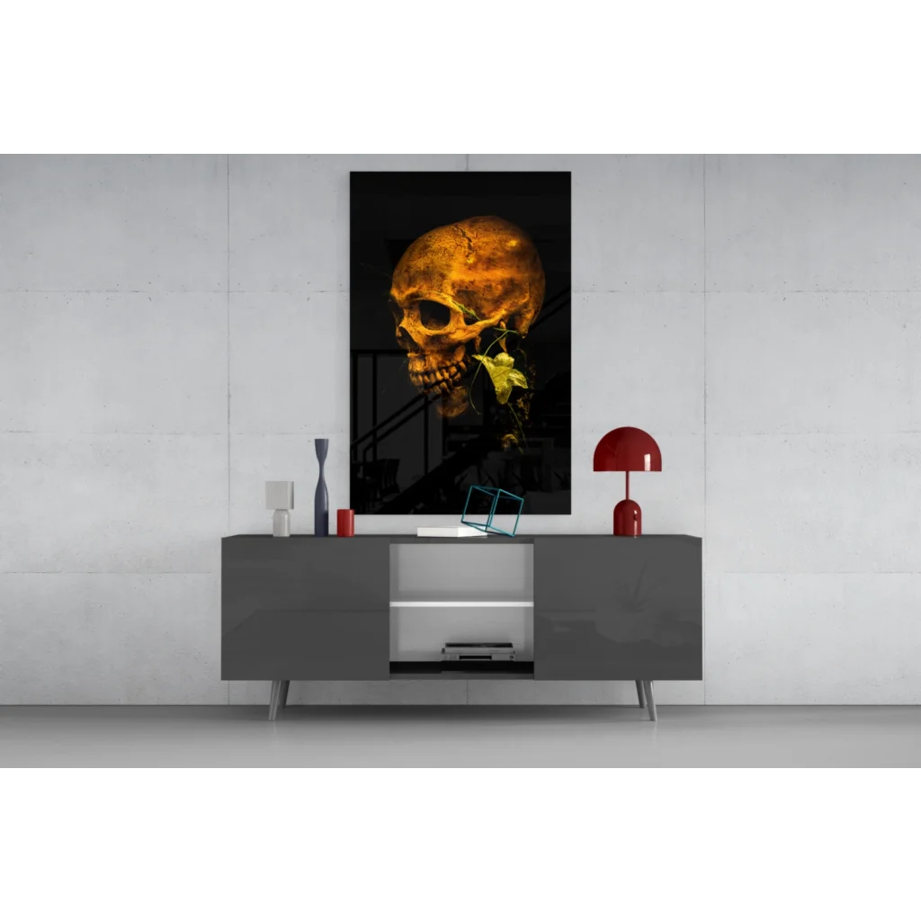 Golden skull glass wall art with green leaf accent on black background