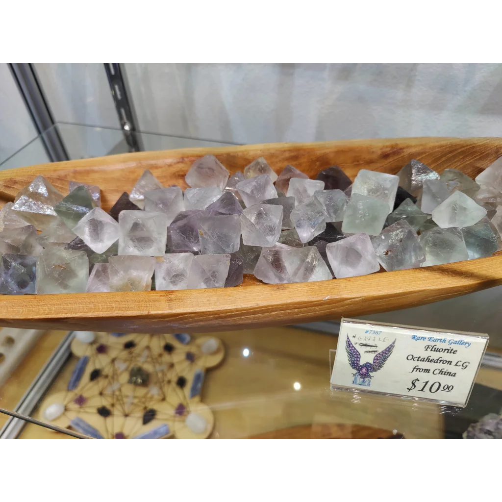 Fluorite octahedron (L) in translucent lavender hues in wooden bowl