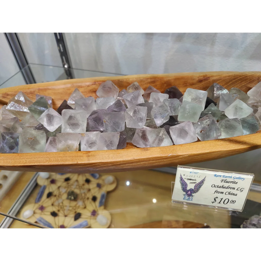 Fluorite octahedron (L) in translucent lavender hues in wooden bowl
