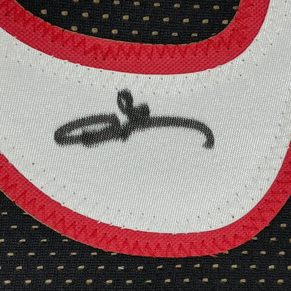 White fabric with red trim and black autograph on framed Allen Iverson jersey with photos