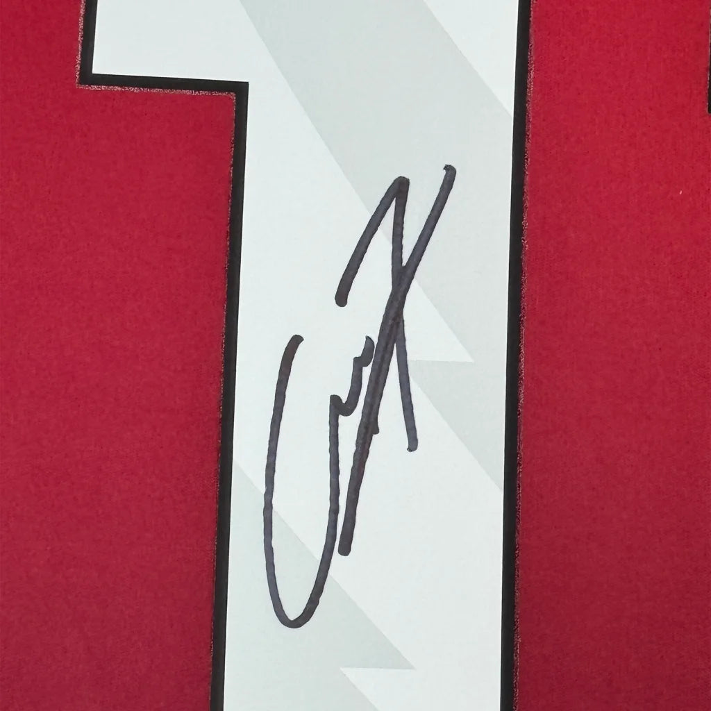 Red and white Manchester United jersey signed with a black marker, framed for collectors
