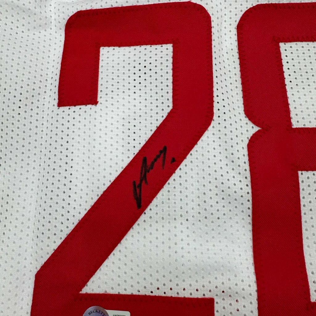 White sports jersey with red numbers and a black autograph, perfect for framing